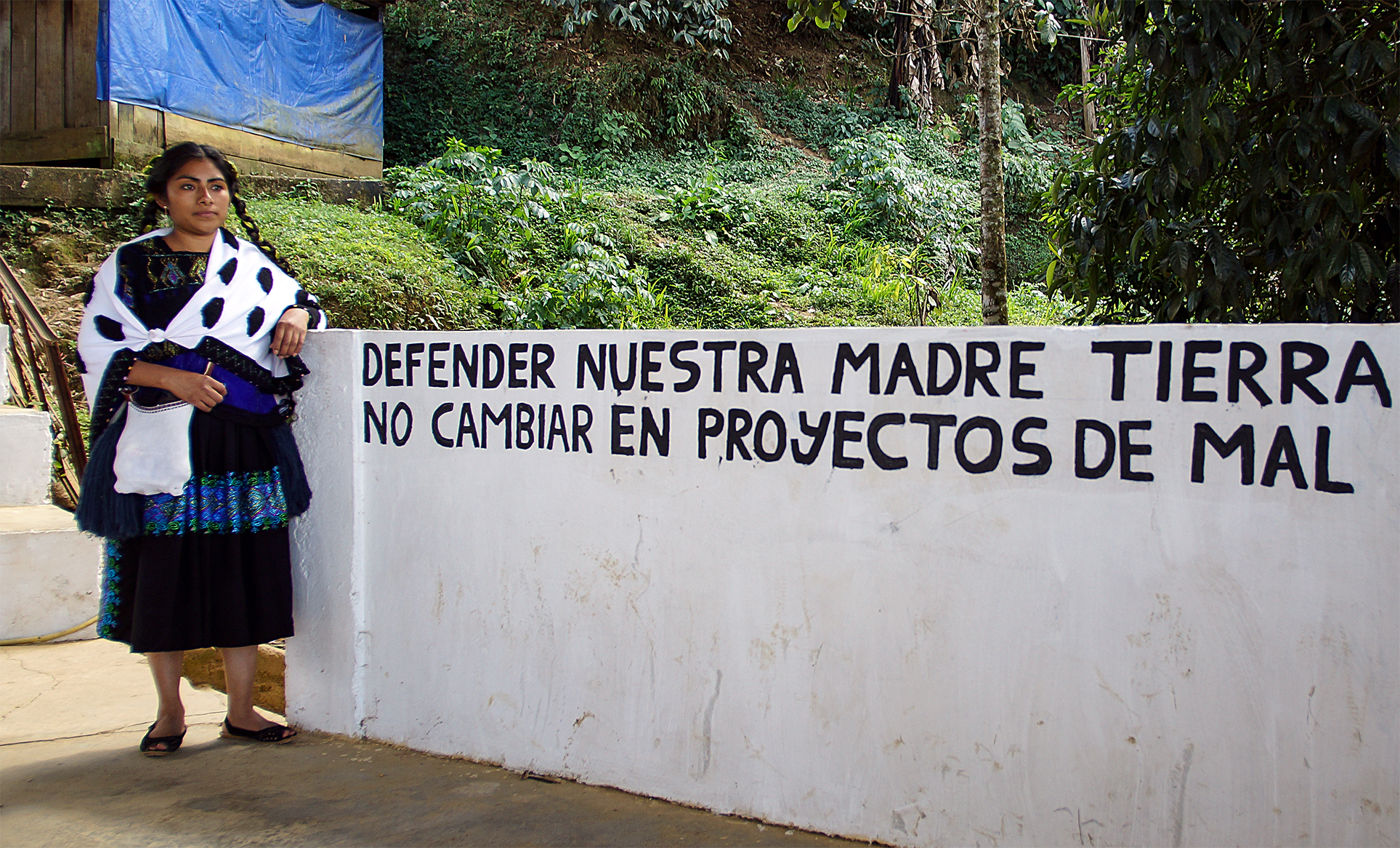 A picture of Guadalupe Vázquez Luna with a sign that says in English, "Defend our mother earth. Do not convert it into bad projects."